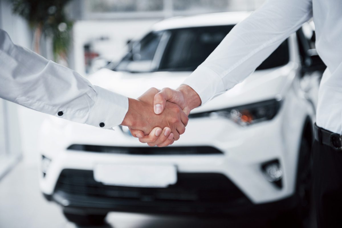 close up sales manager black suit selling car customer 3