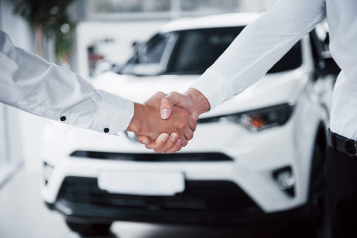close up sales manager black suit selling car customer 3